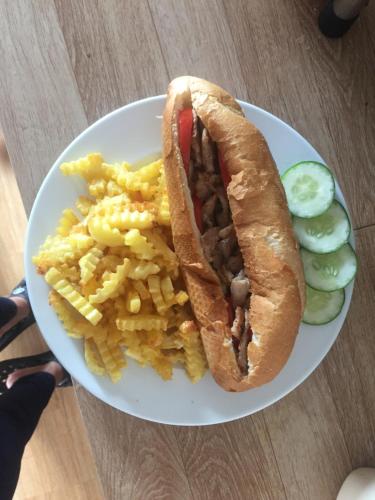 a plate of food with a sandwich and french fries at Sunshine Homestay in Phong Nha