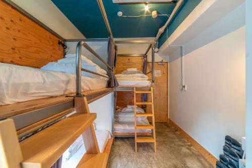 a small room with bunk beds and a ladder at Wise Owl Hostels Shibuya in Tokyo