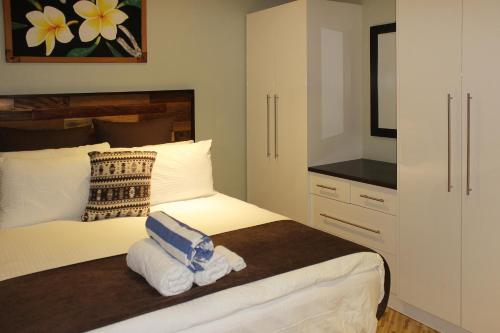 a bedroom with a bed with towels on it at GreyStone Apartments in Nadi