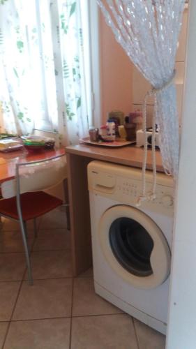 uma máquina de lavar roupa numa cozinha com uma mesa em Aliki's House (Varres) em Zakynthos Town