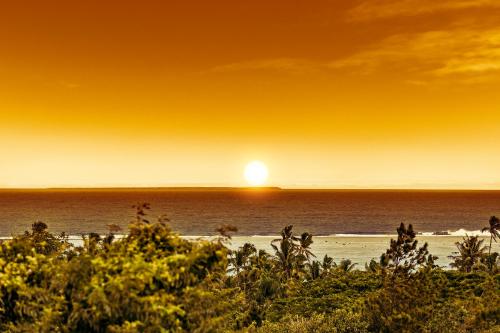 a sunset on the beach with the sun setting at Sea Winds Villas in Singatoka