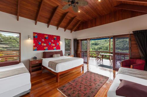 a bedroom with two beds and a balcony at Sea Winds Villa in Singatoka