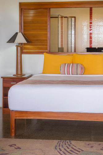 a bedroom with a bed and a lamp on a table at Sea Winds Villas in Singatoka