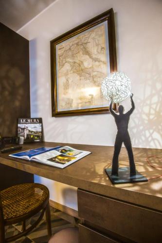 a statue of a man holding up a lamp on a desk at Locanda Mimmo in Bergamo
