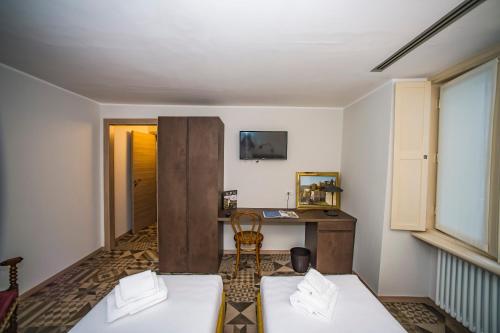 a room with a desk and a table with a chair at Locanda Mimmo in Bergamo