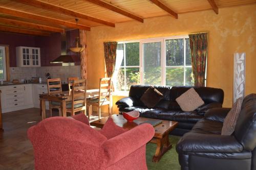 a living room with a couch and a table at Whispering Spirit Holiday Cottages & Mini Ponies in Franklin