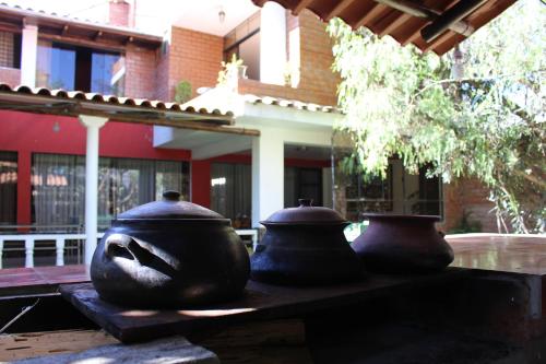 three large vases sitting on a table in front of a building at Casa Hospedaje"Los Capulies" in Carhuaz