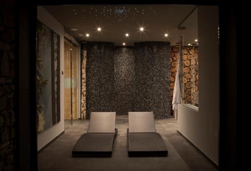 two chairs in a room with a wall of wine bottles at Abba Xalet Suites Hotel in Sispony
