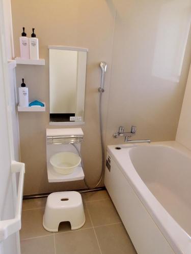 a bathroom with a tub and a toilet and a sink at ウィークリー・マンスリー SORA in Miyako-jima
