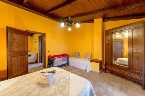 a bedroom with yellow walls and a bed and a tv at Fattoria Capobianco in Montefiascone