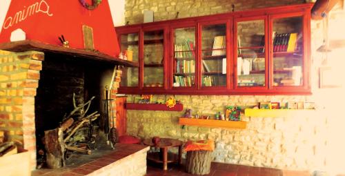 a living room with a fireplace and a red cabinet at Agriturismo Becerca Vegan in Serra San Quirico