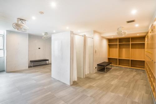 a dressing room with lockers and a bench at Evergreen Place Siam by UHG in Bangkok