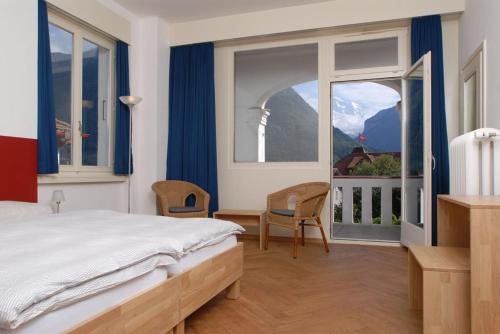 a bedroom with a bed and a large window at Mattenhof Resort in Interlaken