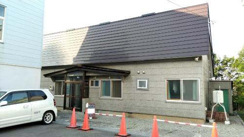 a white van parked in front of a house at Cat Cafe & Stay Cultus's Home in Otaru