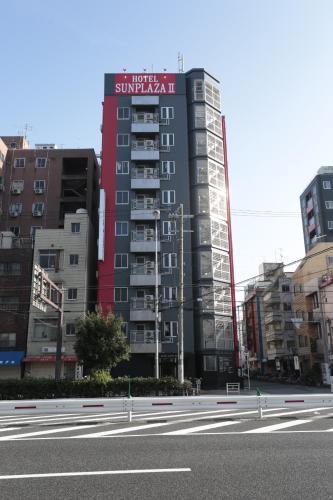un edificio con un letrero al lado de una calle en Hotel Sunplaza 2, en Osaka