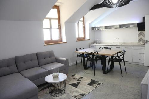 a living room with a couch and a table and a kitchen at Aparthotel Zakątna B&B in Tarnów