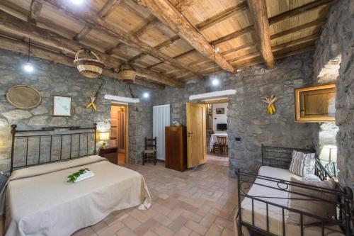 1 Schlafzimmer mit 2 Betten und einer Steinmauer in der Unterkunft Fattoria Capobianco in Montefiascone