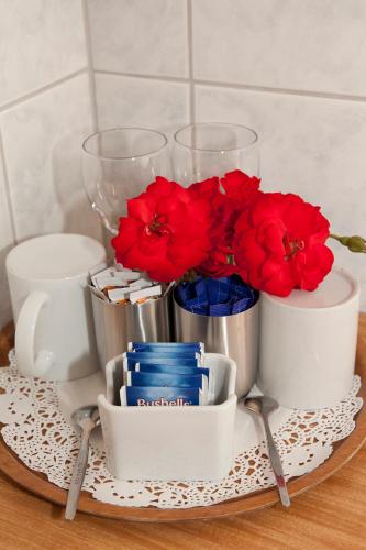 a tray with red flowers and glasses on a table at Manjimup Motor Inn in Manjimup