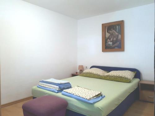 a room with a bed with a chair and a picture at Shell in Rogoznica