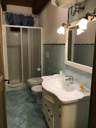 a bathroom with a sink and a toilet and a mirror at Agriturismo Il Casale in Morrovalle