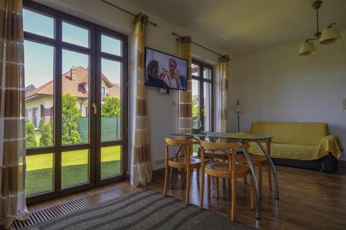 - un salon avec une table, des chaises et une grande fenêtre dans l'établissement Apartamenty z Klimatem, à Ustka