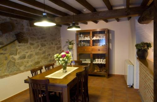 un comedor con una mesa con flores. en Casa rural La Rasa en Cabezas Altas