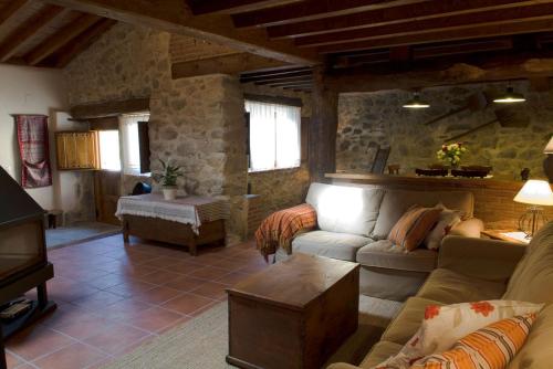 uma sala de estar com um sofá e uma mesa em Casa rural La Rasa em Cabezas Altas