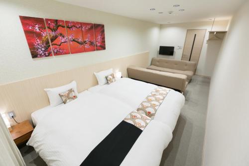 um quarto de hotel com duas camas e um sofá em Stay SAKURA Kyoto Nijo Rikyu em Quioto