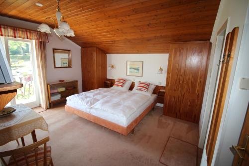 ein Schlafzimmer mit einem Bett und einer Holzdecke in der Unterkunft Haus Wolfgang in Reifnitz