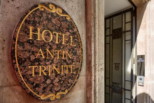 a sign on the side of a hotel arrive time at Hotel Antin Trinité in Paris