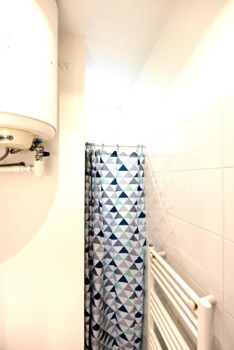 La salle de bains est pourvue d'une douche avec un rideau de douche bleu et blanc. dans l'établissement Appartement 