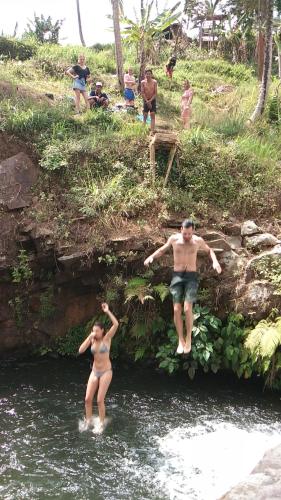 a man and a woman standing in a river at ESA di Kubu Homestay in Singaraja