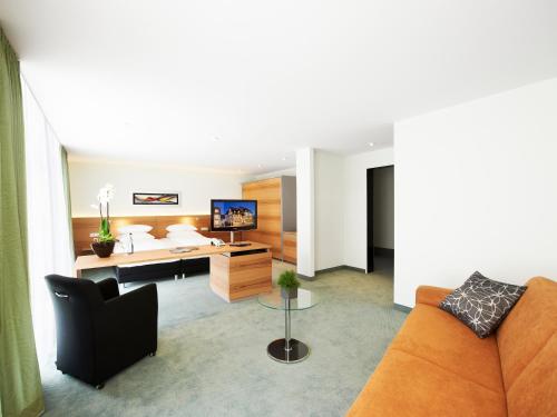 un soggiorno con divano e scrivania di Hirsch Hotel a Ostfildern