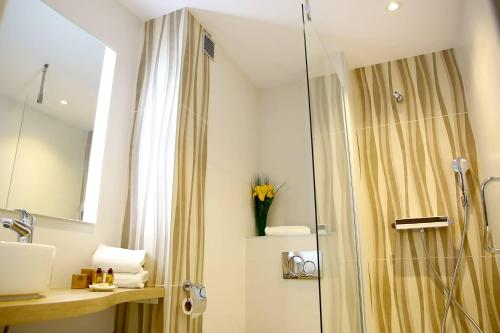 La salle de bains est pourvue d'une douche et d'un lavabo. dans l'établissement Hôtel Restaurant Splendid Camargue, au Grau-du-Roi