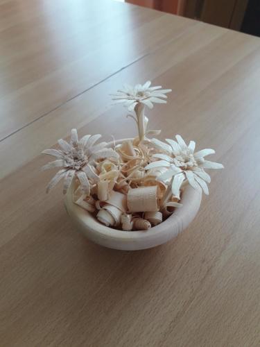 a white bowl with flowers and shells on a table at Appartement Sonnblick Kuschelsuite in den Bergen in Großsölk