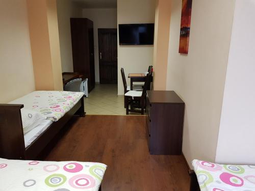 a room with two beds and a desk and a table at Marcus in Bydgoszcz