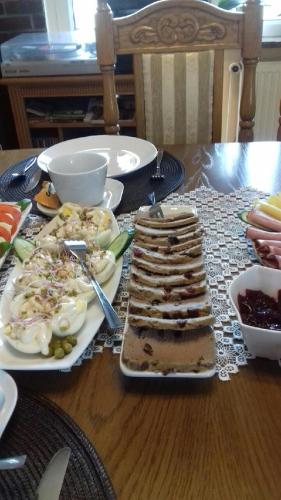 una mesa con platos de comida en una mesa de madera en Dom Gościnny Marcela, en Rewal