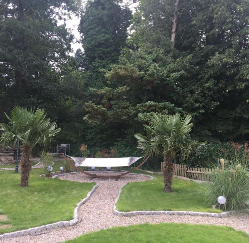 a garden with a bench and palm trees at Gästehaus Schwentineblick in Malente