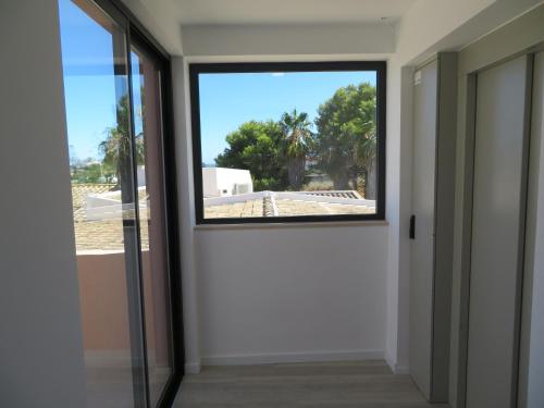a room with a window looking out at a yard at Hotel Alcaide in Portimão