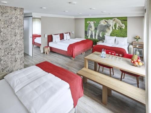 a hotel room with two beds and a table at Hotel Lamm in Ostfildern