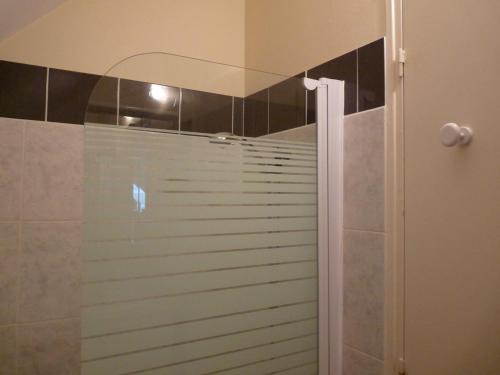 a shower with a glass door in a bathroom at Le Petit Grenier in Bayeux