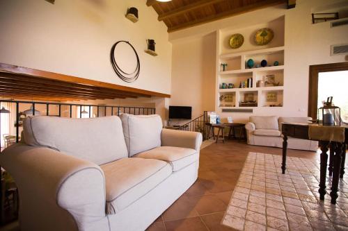 a living room with a white couch and a piano at Casale La Macina - Hotel, Scopello in Scopello