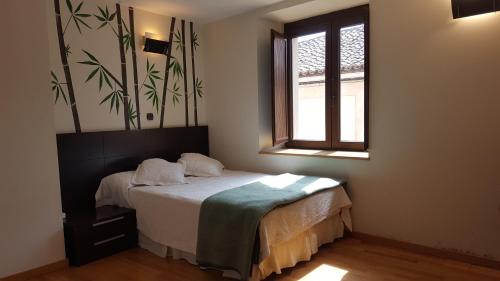 een kleine slaapkamer met een bed en een raam bij Posada Plaza Mayor de Alaejos in Alaejos