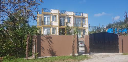 a yellow house with a fence in front of it at Wonderland in Chakvi