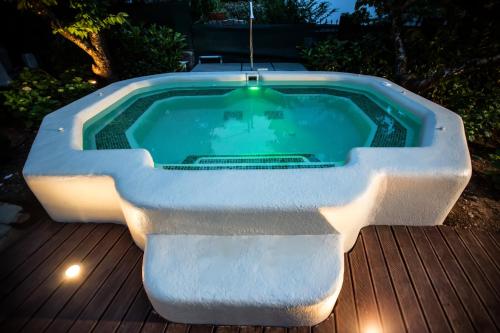a hot tub sitting on a wooden deck with lights at Villa Erifili by Pelion Esties in Agios Georgios Nilias
