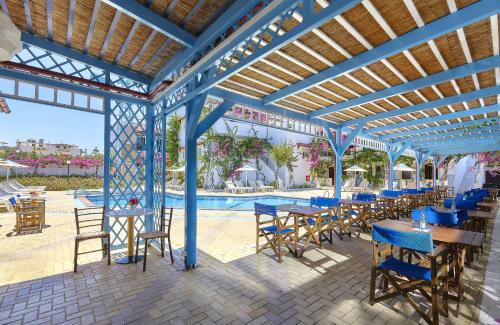 a patio with tables and chairs and a pool at Paul Marie in Hersonissos