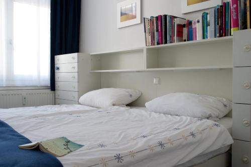 a bed with two pillows and a book on it at Kunst-T-raum in Westerland