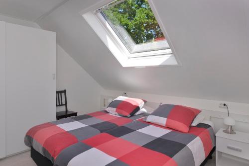a bedroom with a bed and a window at IRISLAAN 9 in Oostkapelle