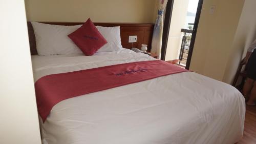 a white bed with a red towel on it at Khách sạn Hữu Phước in Quy Nhon