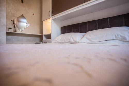 a bedroom with a large bed with white pillows at Venere B&B Castelmola in Castelmola